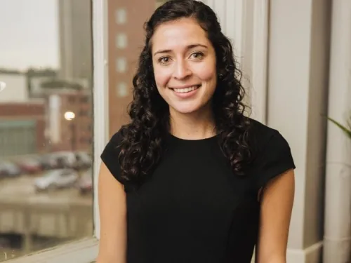 young woman in black dress near window