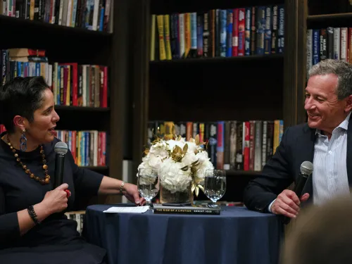 A woman and man sit at a table engaged in dialogue