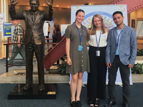 three students near statue in hotel hobby