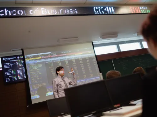 Instructor lecturing at the front of a classroom