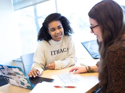 Two students working together at a table