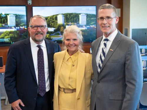 three people in front of computer screens