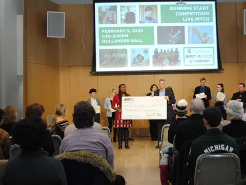 People standing in room holding check