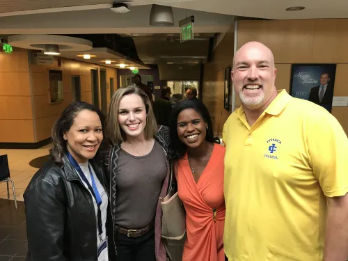 a group of four people pose together