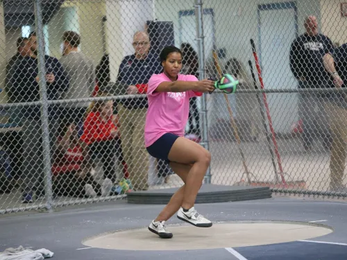 a student in athletic gear doing track and field events.