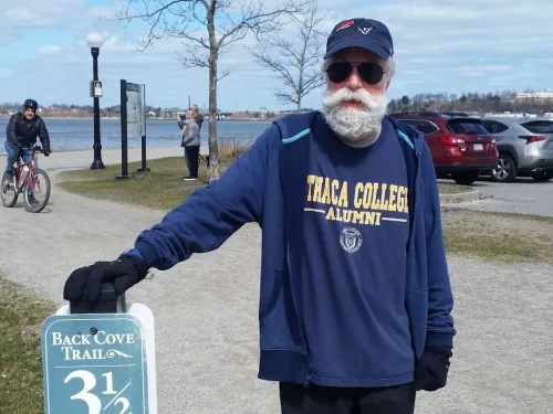 man near a mile marker on a running trail