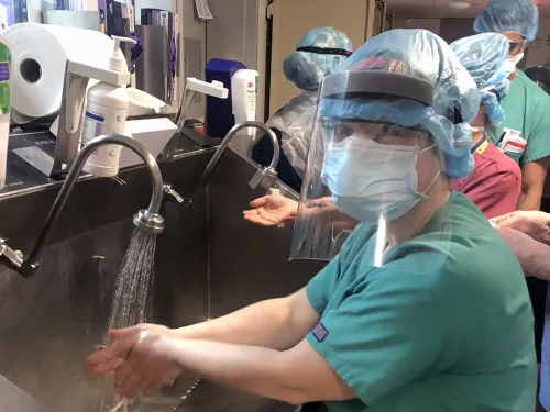 woman in ppe washing hands