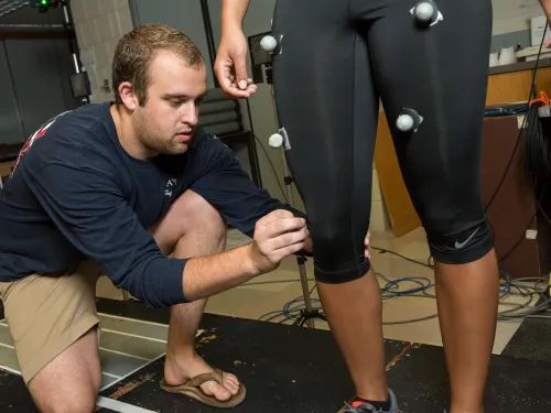 Student putting biomarkers on participant