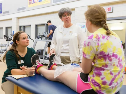 Student assisting in PT with client