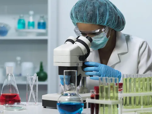 Woman staring into a microscope