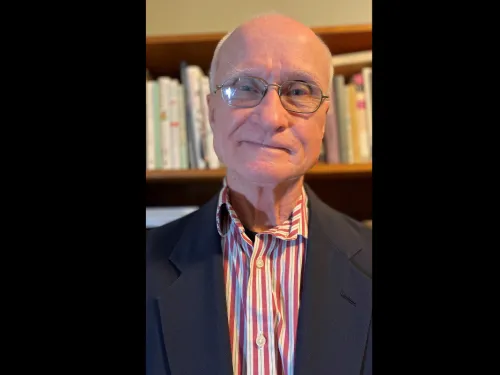 Bernard Beins standing in front of a bookshelf