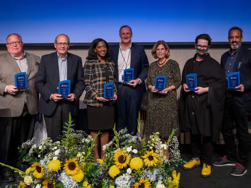 Alumni Award Winners standing on stage holding their awards