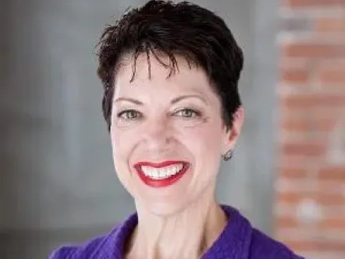 Person with short dark hair smiling