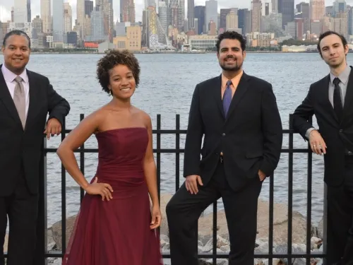 four people standing in front of city skyline