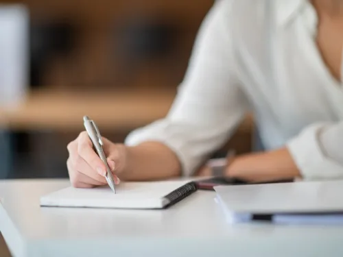 person writing in notebook