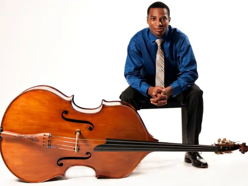 man sitting with bass on its side
