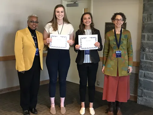 Alison Lipton and Megan O'Reilly standing in between the president and provost