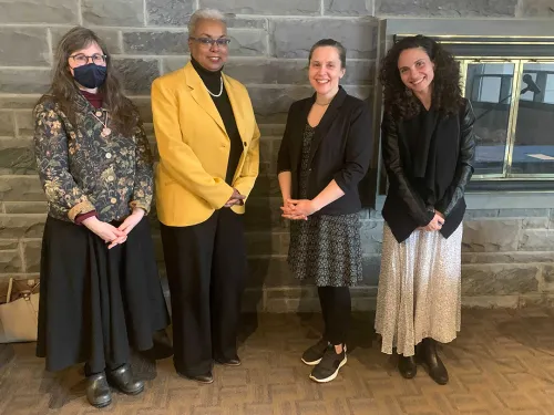 Cathy Michael, La Jerne Terry Cornish, Chrystyna Dail, and Lauren Goldberg standing in front of a fireplace