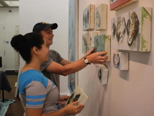 Ithaca College students hang artwork in the Handwerker Gallery