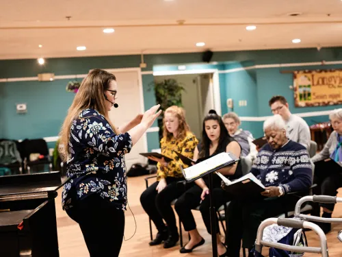 a woman conducting a group of student musicians