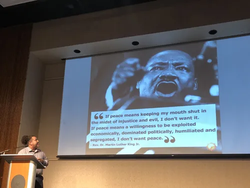 Michael Benitez Jr.,  standing at a lectern