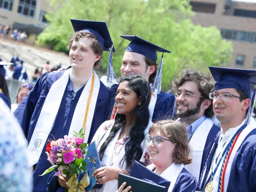 group of graduates in caps and gowns poses together