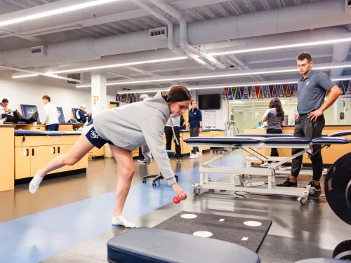 Student is practicing a balance and strength building exercise in the athletic training clinic.