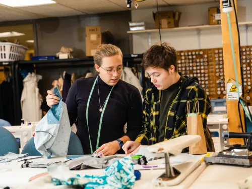 two students work in the costume shop