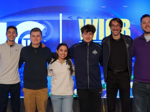 Six college students stand in a group photo. 