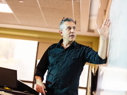 professor teaching in front of a white board 