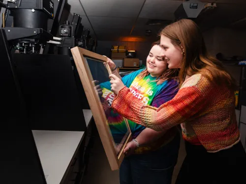 two female students looking at a photograph