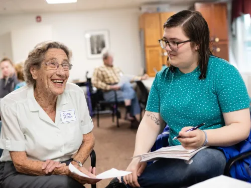 A female student sits and talks with a female Longview resident