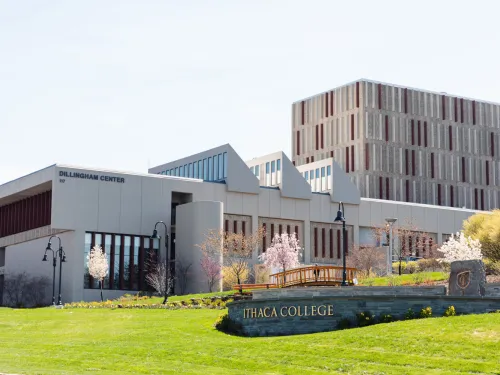 Ithaca College sign with Dillingham Center building in the background
