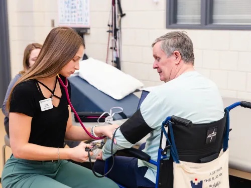 a female student takes a patient's blood pressure 