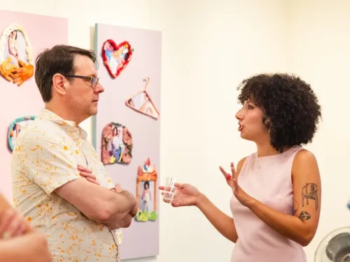 A female student talks with an older man in an art gallery 