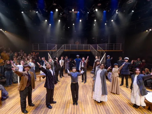 Performers on stage with arms raised.
