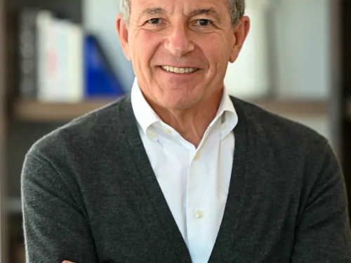 smiling man wearing a sweater over a white shirt