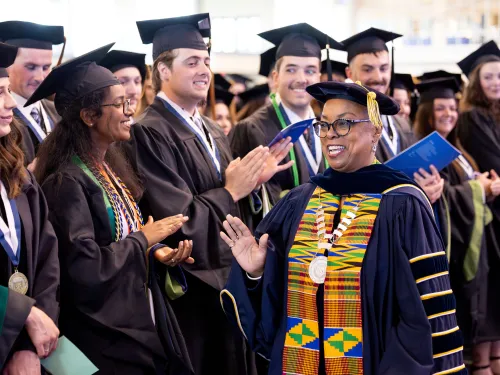 People wearing mortarboards and gowns at a commencement ceremony. 