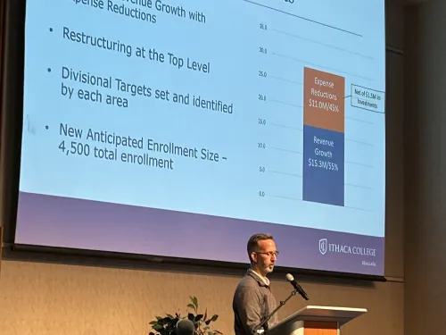 Man stands at a lectern with a slide projected behind him.