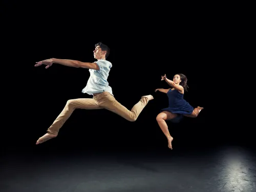 Two dancers leaping through the air.