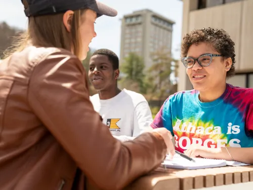Students interacting on outdoor patio.
