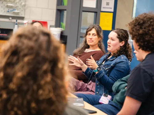 a group of students sits around a table having an animated discussion