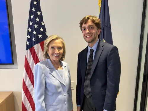 Student intern standing with Hillary Clinton