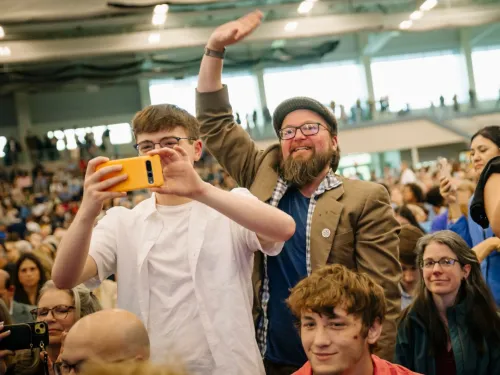 Excited family members wave from the audience 