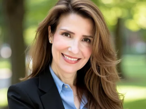 Woman with long hair wearing a blue blazer and blue shirt.