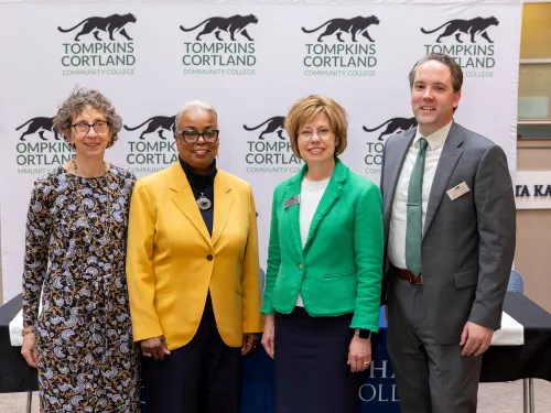 A group of people smile at a press conference.