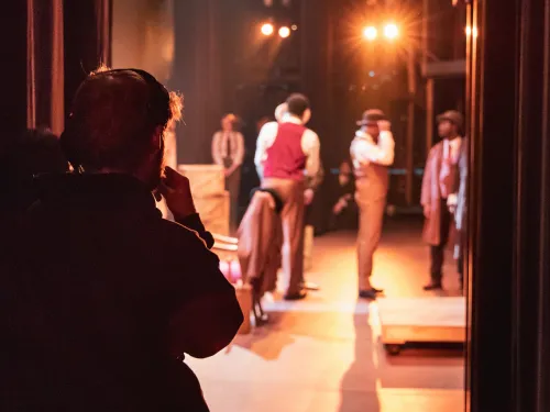 a theatre management student watching a performance backstage