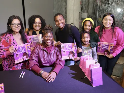 Fans and friends gather around author Jaylene Clark Owens '10 at a book event.