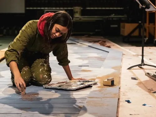 student painting some stage props