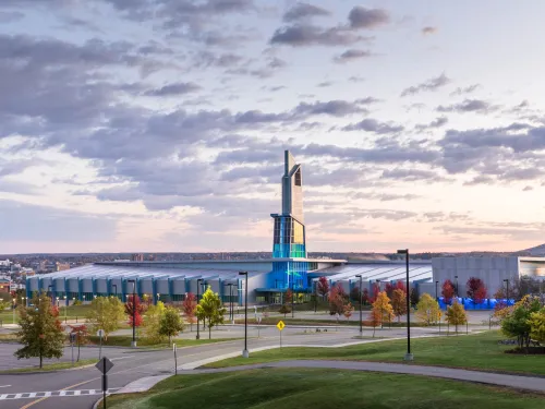 Image of Athletics and Events Center on partly cloudy sunrise backdrop.